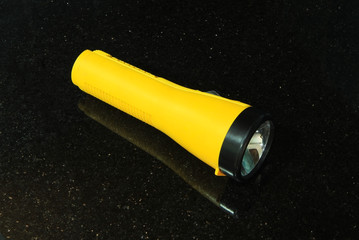 Yellow flashlight isolated on black background