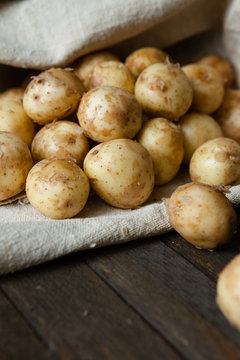 young (baby) potatoes in a sack on the wooden table