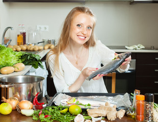 woman putting  saltwater fish into sheet pan