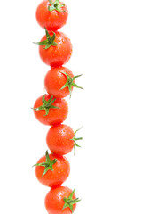 cherry tomatoes in drops of water on a white background