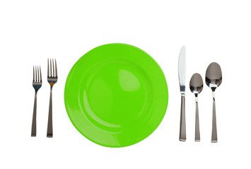 Green plate, forks, knife and spoons isolated on white