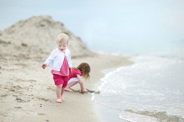 Naklejka premium Adorable toddler girl on a sandy beach