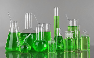 Test-tubes with green liquid on gray background