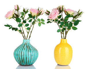 Beautiful pink and white roses in vases isolated on white