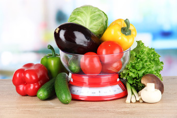Fresh vegetables in scales on table in kitchen