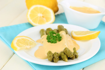 Asparagus on plate, on wooden background