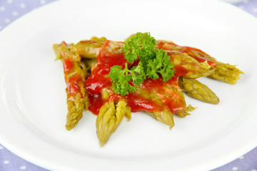 Asparagus on plate, on wooden background