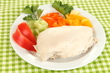 Boiled chicken breast on plate with vegetables close up