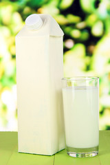 Milk pack on table on bright background