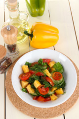 Light salad in plate on wooden table