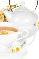 Cup of herbal tea with camomiles close up