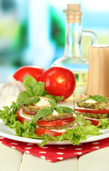 Tasty roasted marrow and tomato slices with salad leaves,