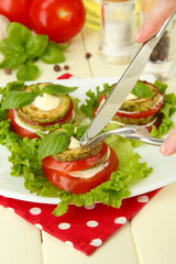 Tasty roasted marrow and tomato slices with salad leaves,