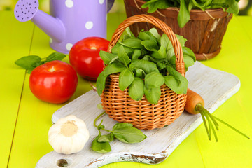 Fresh herb in basket on wooden table on natural background