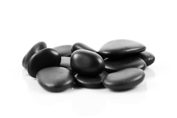 Black massage stones stacked, isolated.