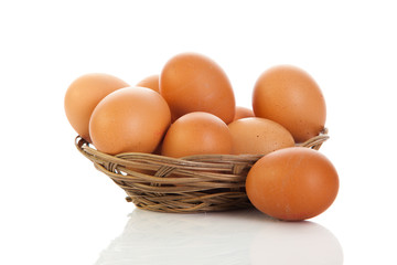 Brown eggs in the basket on white.