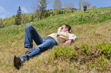 Naklejka na ściany i meble Man lying on a steep hillside