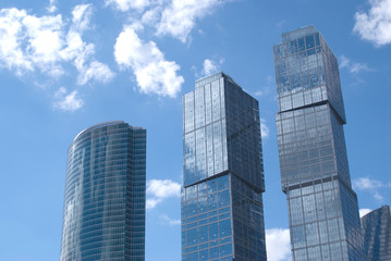 Three modern office buildings in a city over blue sky