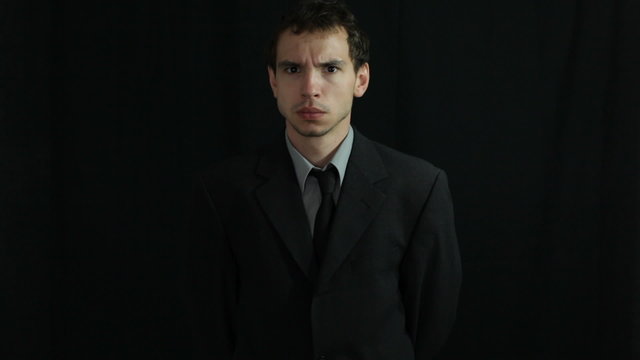 Young businessman over dark background