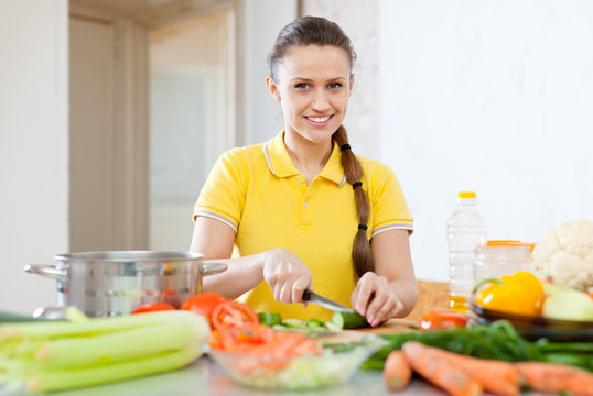 woman in yellow chopping  vegetables