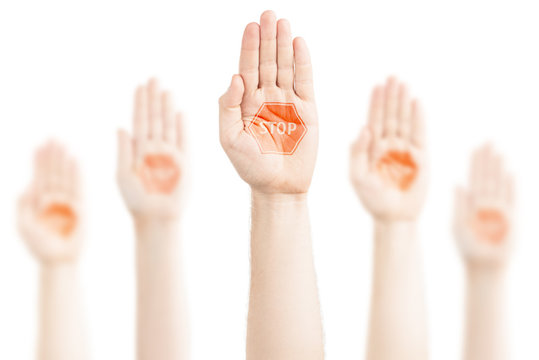 Hands raised to the sky with a stop sign.