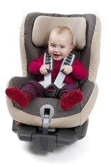 child in booster seat for a car in light background