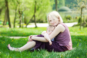 Naklejka na ściany i meble Mother with her child take rest in park