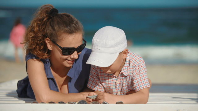 Mom and baby lying on a deck chair on the beach