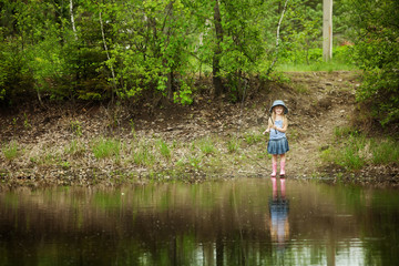 Fototapeta na wymiar Little girl are fishing on lake in forest