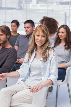 Woman smiling at camera in group therapy