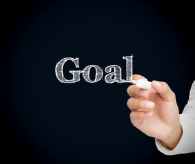 Man writing goal on a blackboard