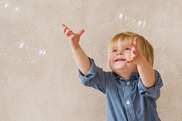 Very happy kid trying to catch soap bubbles