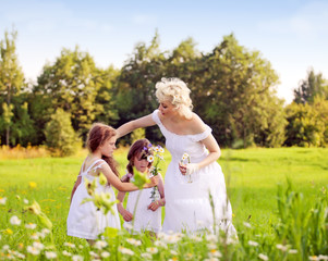 Mother and daughters relaxing on the meadow