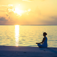 Caucasian woman practicing yoga at seashore