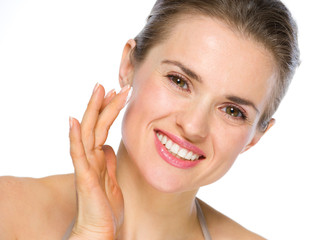 Fototapeta premium Beauty portrait of smiling young woman applying creme