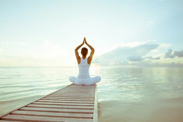 Foto op Plexiglas Yogaschool Blanke vrouw die yoga beoefent aan de kust
