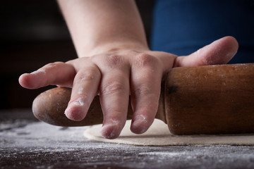Hand on a rolling pin preparing pizza dough
