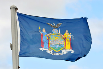 Flag of New York State in blue sky background