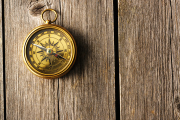 Antique compass over wooden background