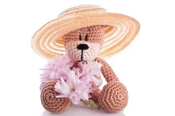 brown stuffed animal teddy bear with pink blossom
