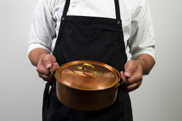 chef holding copper pan