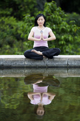 Fototapeta na wymiar Asian woman doing yoga by the lake