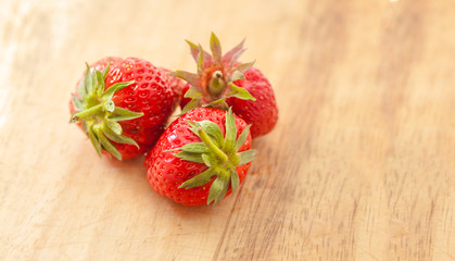 three strawberries on wooden table