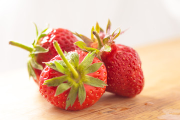 three strawberries on wooden table