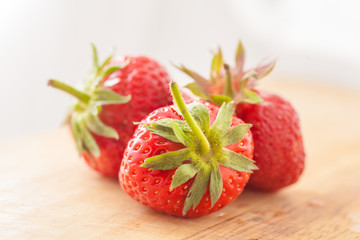 three strawberries on wooden table