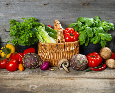fresh herbs and vegetables on wooden background