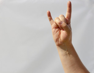 man hand shows heavy metal sign closeup against white