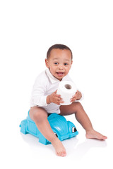 African child on potty play with toilet paper, isolated over whi - obrazy, fototapety, plakaty