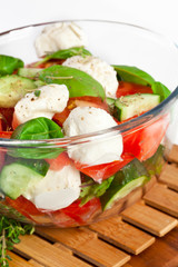 Fresh salad in a stylish white bowl. Isolated on white.