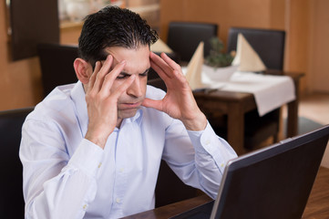 Mann im Lokal gefrustet vor LapTop